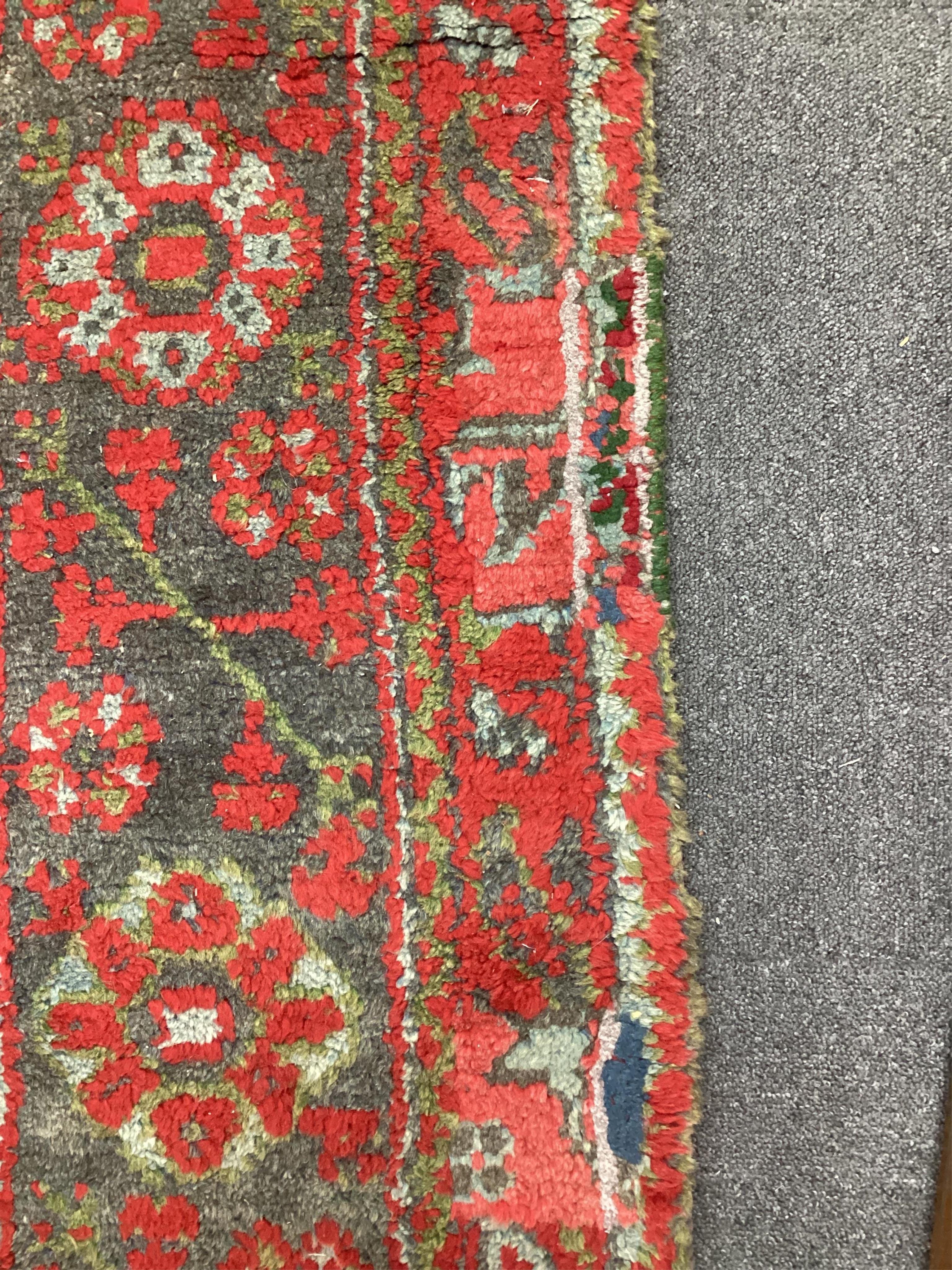 A large Turkish carpet, with triple row of stylised medallions on a red ground, multi bordered, 413 x 345cm. Condition